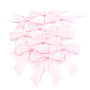 Noeuds en ruban satin rose avec fil, gros plan pour emballage cadeau et decor de fete.