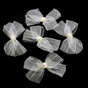 Detailed shot of white organza pleated bows, perfect craft accessories for clothing and gift packaging.