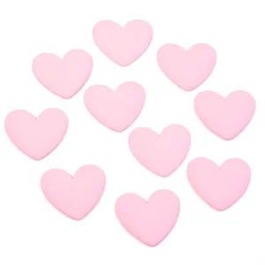 Close-up of cute pink heart resin flatback charms for phone case and DIY jewelry crafting.