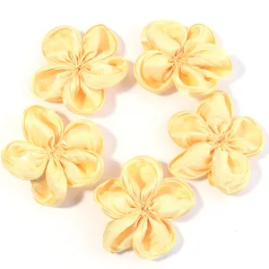 Close-up detail of yellow satin 5-petal flower DIY handmade hair accessories and craft supplies