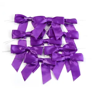 Nœuds en ruban de satin violet avec attache torsadée pour emballage cadeau et fête.