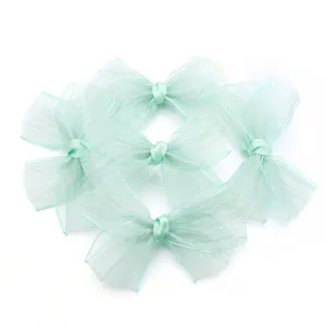 Close-up detail of light green organza sheer bowknot DIY accessories for crafts and apparel.