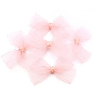 Detailed view of large pink organza bows, delicate pleated ribbon design for crafts.