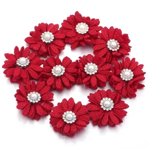 Detalle de flor de tela roja con perla y estrás para accesorio de ropa de manualidades.