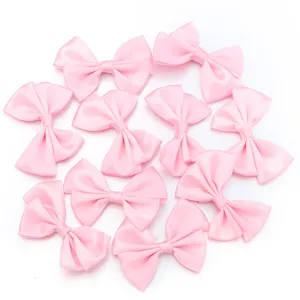 Détail de nœud double en satin rose, parfait pour les pinces à cheveux et accessoires.