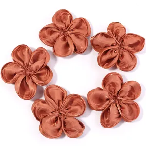 Detailed closeup of glossy satin five-petal fabric flowers, perfect for DIY hair clips.
