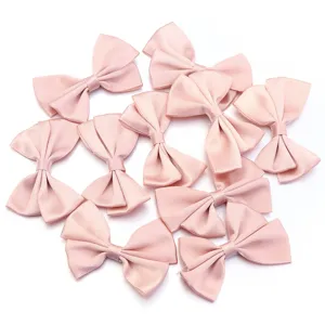 Vue détaillée de nœuds doubles en polyester rose, parfaits pour accessoires de bricolage et vêtements.