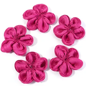 Closeup detail view of five vibrant magenta satin fabric flower DIY hair accessory patches.