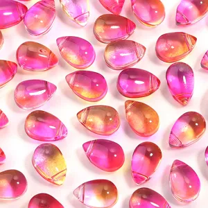Close-up of pink orange gradient teardrop glass beads for DIY jewelry and crafts making.