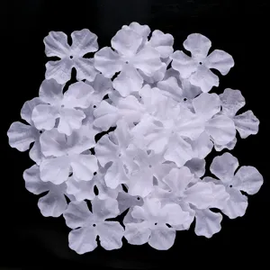 Close-up of white four-petal fabric flower DIY patches for hairpins and clothing crafting.