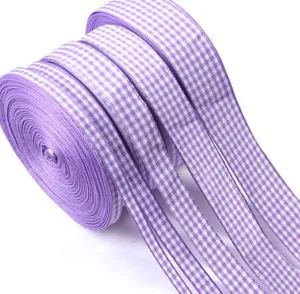 Dettaglio del rotolo di nastro a quadri viola, materiale in tessuto per confezioni regalo.
