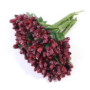 Nahaufnahme künstlicher zweifarbiger Beeren mit grünen Blättern für DIY-Blumenkunst.