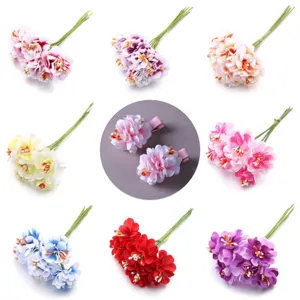 Vista detallada de ramos de flores de tela artificial y pinzas para el cabello para manualidades.