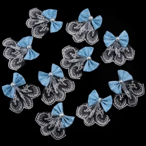 Vue détaillée d'appliques de nœuds bleus à pois avec tulle de dentelle blanche et perles.