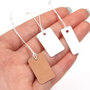 Close-up detail of blank white and craft paper hanging tags with elastic strings for jewelry.