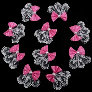 Nœud rose à pois avec dentelle blanche et perle, vue détaillée d'accessoire de coiffure et garniture.