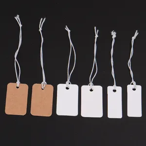 Close-up of blank paper price tags with white elastic strings for jewelry and clothing display.