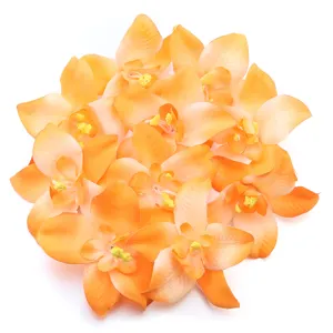 Artificial orchid flower heads detail, vibrant orange fabric flowers for decoration.