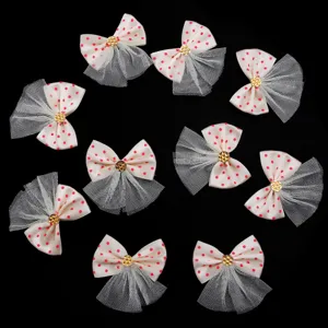 Vue détaillée de nœuds en tissu tulle à pois rouges avec strass doré pour accessoires DIY.