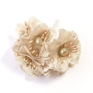 Detalle ramo de flores camelia de tela artificial malla con purpurina dorada decorada