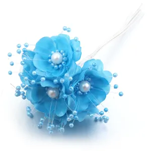 Vista detallada del ramo de flores de tela artificial azul con estambres de perlas.