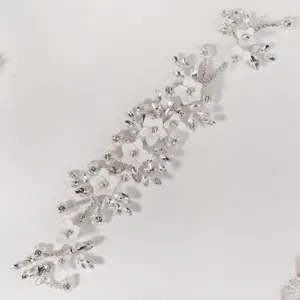 Prachtig detail van bloemenhaarwijnstok met witte keramische bloemen, strass-steentjes en parels.