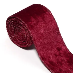 Detalle en primer plano del rollo de cinta de terciopelo rojo oscuro con borde de alambre dorado.