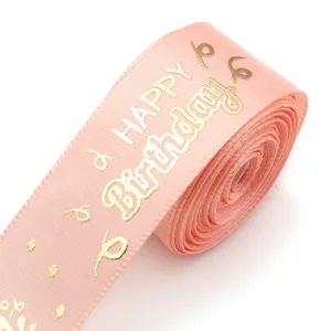 Pink polyester ribbon with gold foil happy birthday print for gift wrapping and party decor.