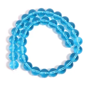 Close-up view of lake blue transparent glass round beads, perfect for DIY jewelry making detail.