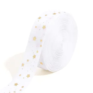 Close-up of white flocked ribbon with golden star print, perfect for DIY crafts and hair accessories.
