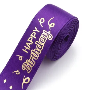 Purple gold stamped happy birthday ribbon roll, detailed view of satin fabric for gift wrapping.