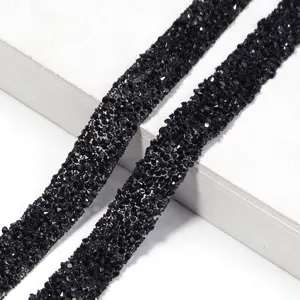 Detalle de cinta de diamantes de imitación de resina negra, accesorio de ropa brillante.