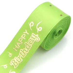 Close-up of lime green polyester ribbon with gold foil Happy Birthday text for gift wrapping.