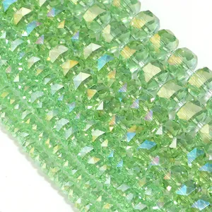 Close-up shot of sparkling light green faceted crystal spacer beads with stunning fire.