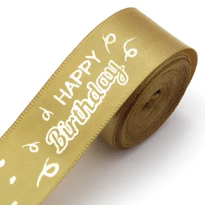 Gold satin ribbon close-up with white happy birthday print, ideal for gift wrapping and parties.
