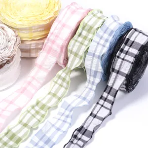 Close-up detail of colorful plaid ruffled fabric ribbon rolls, perfect for DIY bows and sewing.