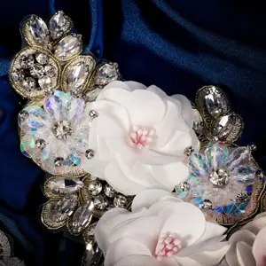 Primer plano de una aplicación floral de tela y pedrería hecha a mano con detalles.