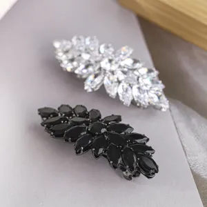 Vue détaillée de pinces à cheveux en cristal marquise noir et blanc avec strass étincelants.