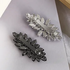 Gros plan de pinces à cheveux à strass marquise, base métallique et cristaux étincelants.