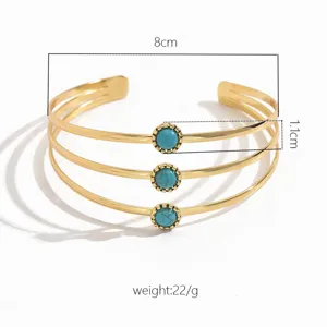 Primo piano dettagliato del bracciale manche oro multistrato con pietre turchese e misure.