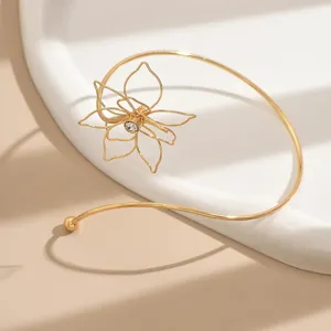 Dettaglio in primo piano dell'elegante bracciale da braccio in filigrana dorata con strass.