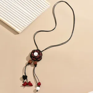 Trendy long sweater chain with red tweed camellia flower pendant and delicate charms for women.