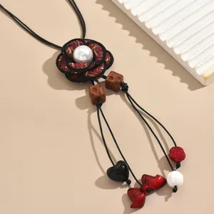 Long sweater chain necklace featuring a fabric flower pendant with pearl and cute charms.