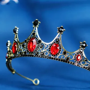 Close-up view of a vintage baroque crown featuring sparkling red and black rhinestones.