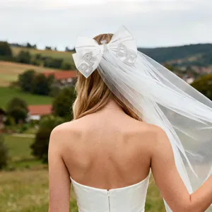 Detailansicht des weißen Satin-Schleier-Bogens mit funkelnden Strass-BRIDE-Buchstaben u. Tüll.