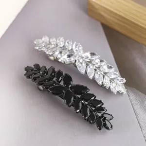 Gros plan de pinces à cheveux exquises en zircon marquise avec des cristaux noirs et clairs.