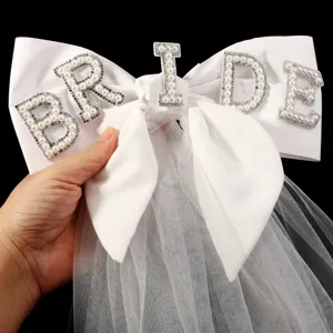 Nahaufnahme der weißen Satin Braut Haarschleife mit Perlen Strass BRIDE Buchstaben und Tüll.