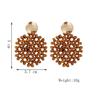 Bohemian geometric wooden beaded drop earrings with golden disc detail, stylish design.