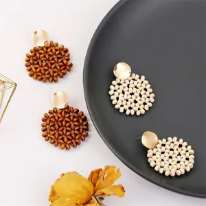 Handcrafted wooden bead earrings, bohemian circular design with gold-tone metal studs detail.