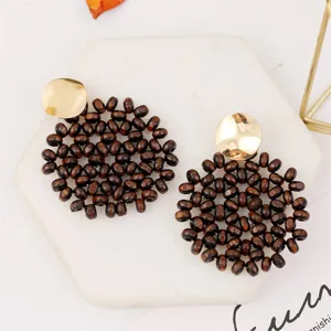Handmade wooden bead bohemian geometric earrings with gold metallic top detail view.